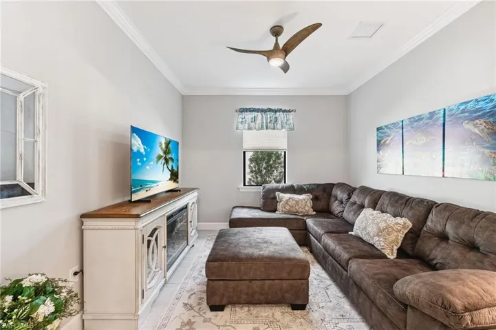 Living room with crown molding and ceiling fan