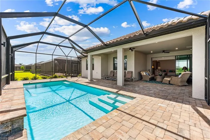 View of pool featuring an outdoor living space, a lanai, a patio area, and ceiling fan