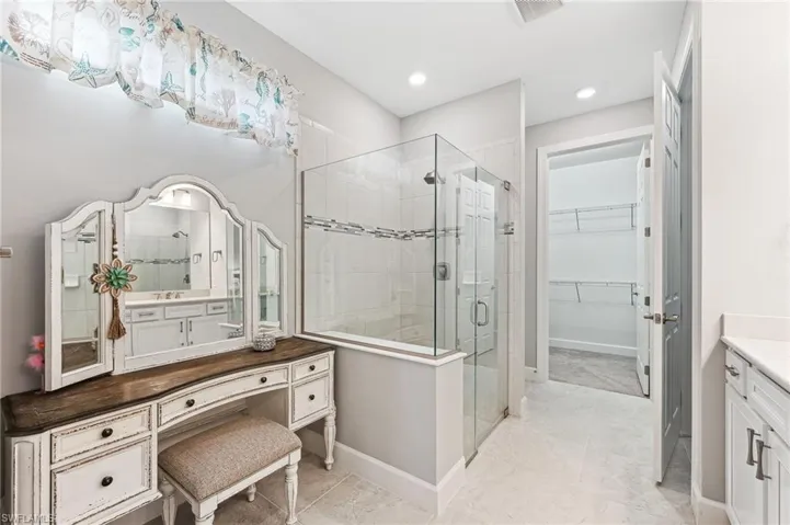 Bathroom with a shower with shower door and vanity