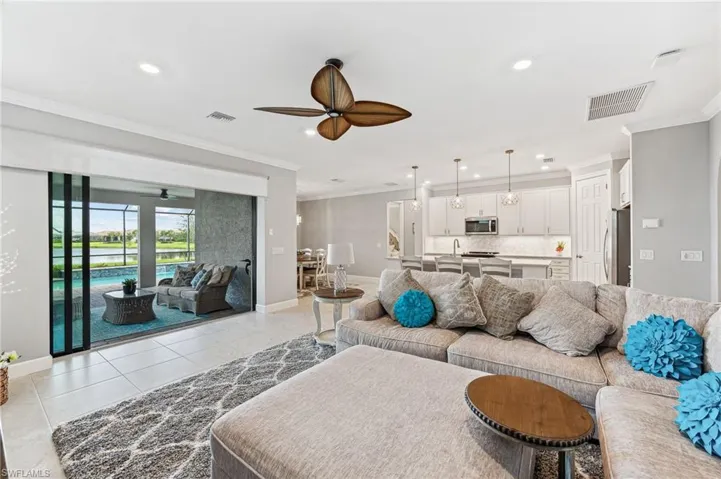 Tiled living room with crown molding and ceiling fan