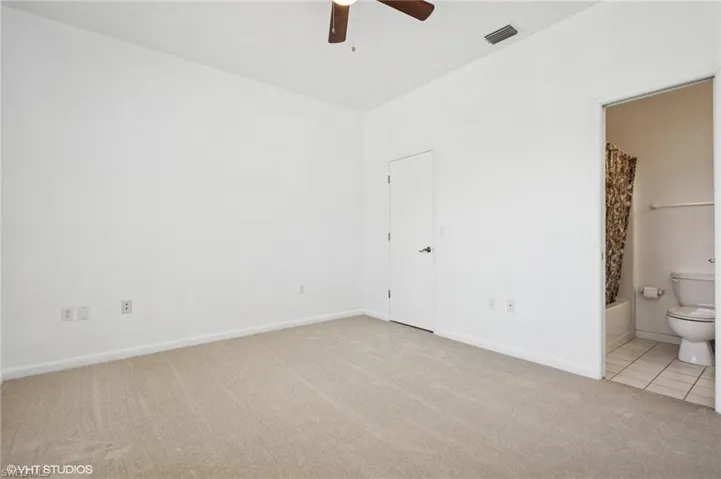 Bedroom #4 - with baseboards, visible vents, tile patterned floors, ensuite bathroom, and carpet floors
