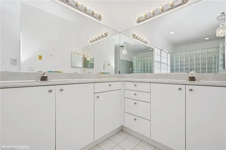Full bathroom featuring tile patterned flooring, a sink, and double vanity