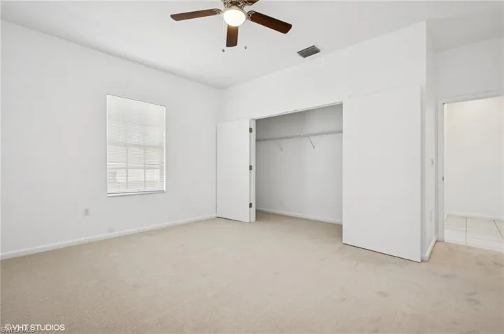 2nd bedroom with new carpet, a ceiling fan