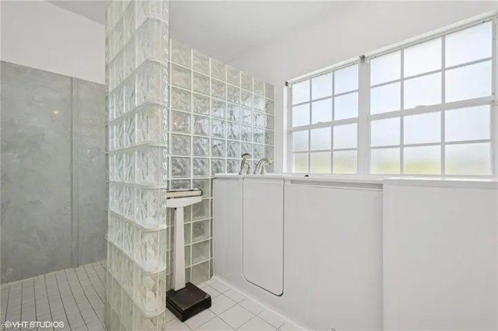 Full bath with tile patterned flooring, a walk in shower AND walk in sitting jet tub.
