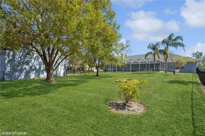 View of yard featuring a lanai and fence
