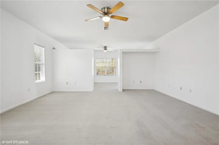 Primary bedroom with separated sitting area/office, a new ceiling fan, and new carpet