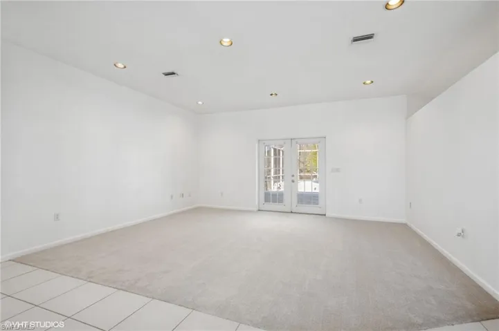 Living room with access to covered pool deck featuring NEW carpet, french doors, and recessed lighting