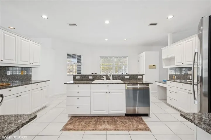 Kitchen featuring light tile patterned floors,  decorative backsplash, new stainless steel appliances, and a sink