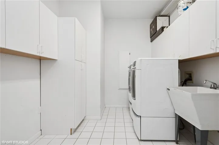 Spacious laundry room with much storage. featuring washer / clothes dryer, cabinet space