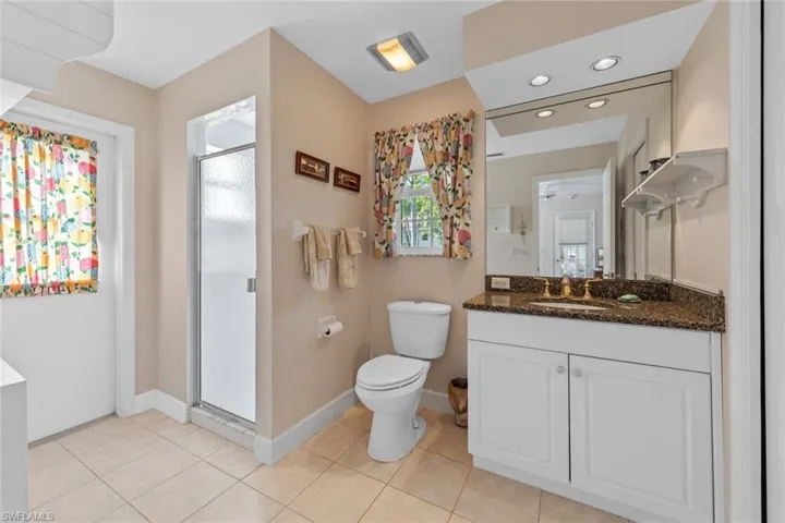 Full bathroom featuring vanity, a shower stall, toilet, and tile patterned flooring
