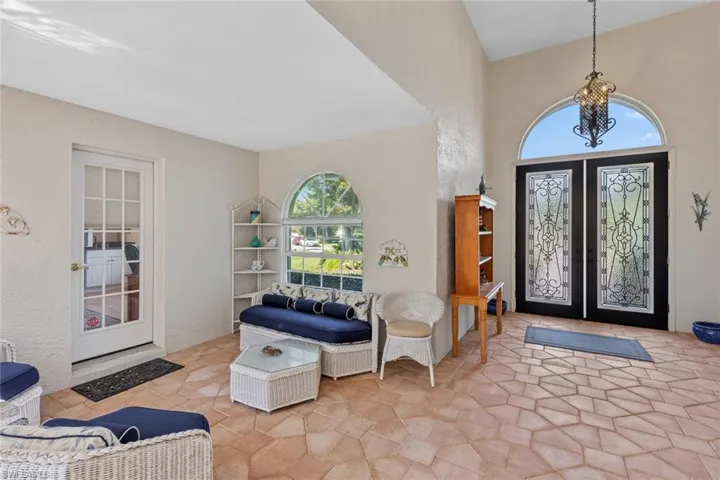 Foyer entrance with stone finish floor, french doors, and a textured wall