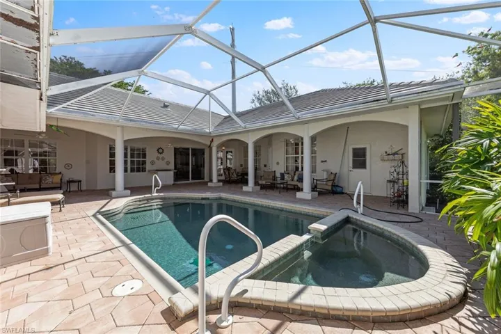 View of pool with an outdoor living space, a pool with connected hot tub, and a patio
