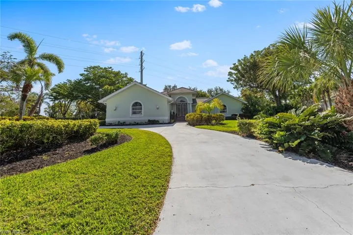 Single story home featuring stucco siding, concrete driveway, and a front yard
