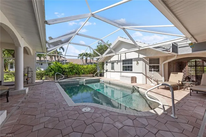 View of swimming pool with a patio area, a lanai, and a pool with connected hot tub