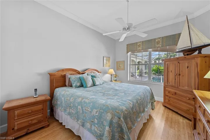 Bedroom with crown molding and light wood finished floors