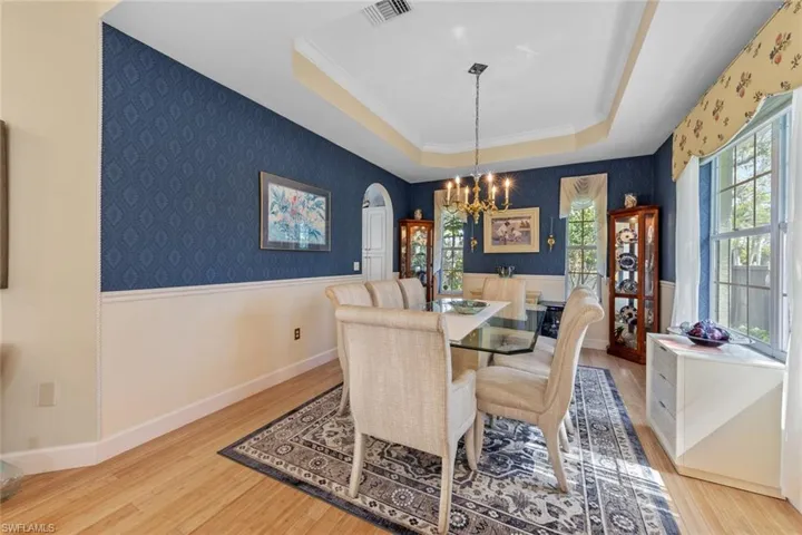 Dining room with wallpapered walls, a raised ceiling, and visible vents