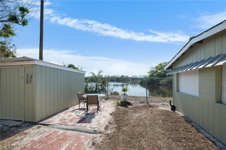 View of patio featuring a water view and a storage unit