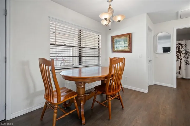 Dining area with wood finished floors and a chandelier