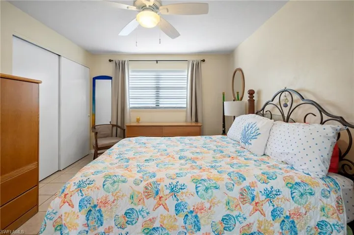 Bedroom featuring a closet, light tile patterned floors, and a ceiling fan