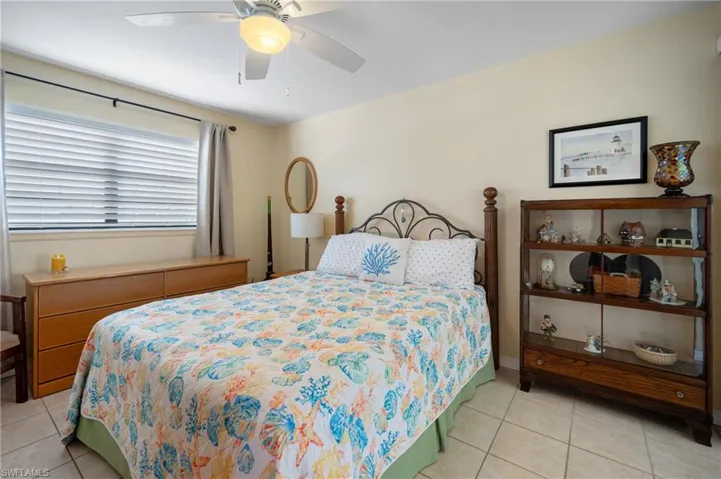 Bedroom with light tile patterned floors and a ceiling fan