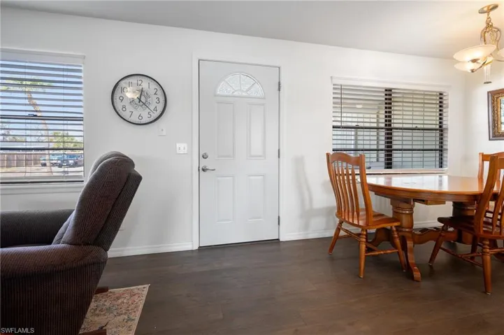 Dining area with dark wood-style floors and baseboards