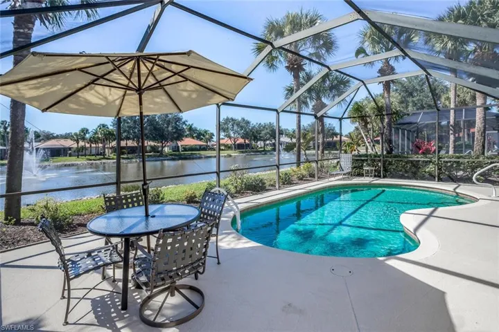 Lanai with inground solar heated pool overlooks a lovely lake view including water features.  Lots of patio area around the pool.