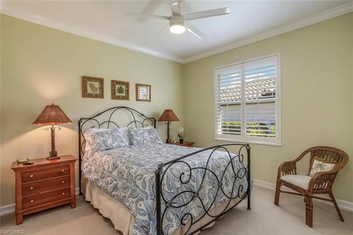 Carpeted guest bedroom with crown molding and ceiling fan