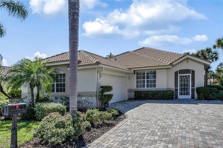 ~1700 sf turnkey home with tasteful landscaping, decorative driveway, side entry garage, and a tile roof