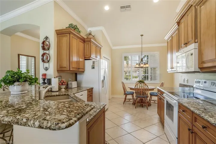 Kitchen with appliances, wood cabinets, dinette, pantry, a kitchen breakfast bar/peninsula