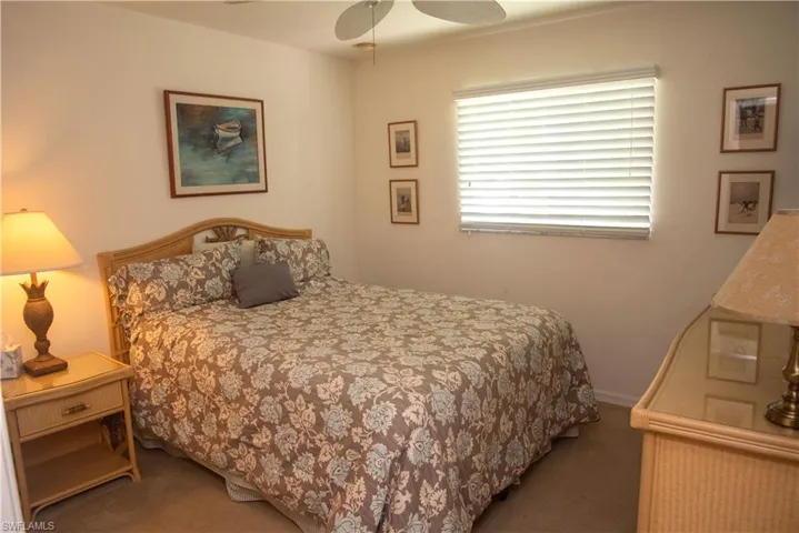 Carpeted bedroom featuring ceiling fan