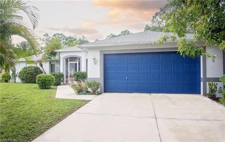 Single story home with a garage and a yard