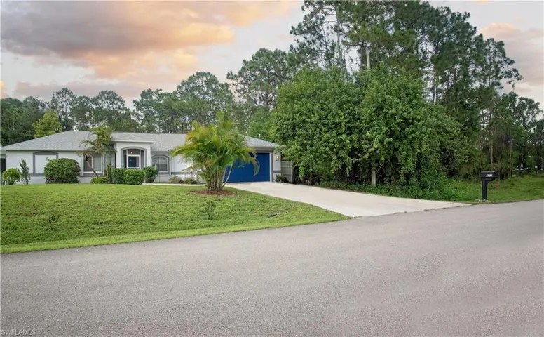 View of front of house featuring a garage and a yard