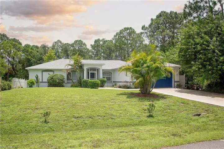 View of front of home featuring a garage and a lawn