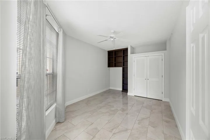 Unfurnished bedroom with ceiling fan and a closet