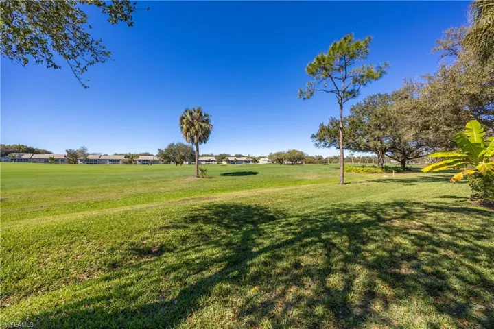 View of green lawn with golf course view and a residential view