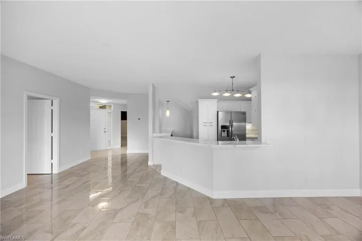 Unfurnished living room featuring baseboards