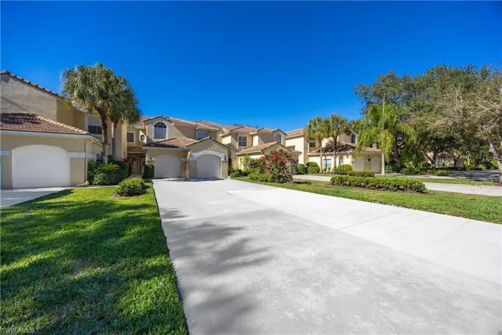 Mediterranean / spanish-style house with concrete driveway, stucco siding, a residential view, a front yard, and a tile roof