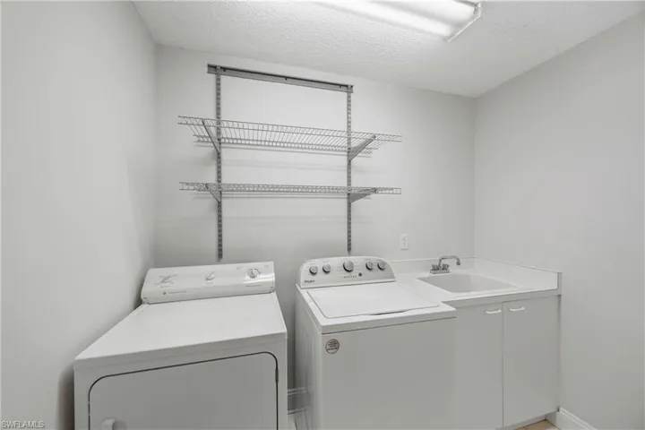 Washroom featuring a textured ceiling and separate washer and dryer