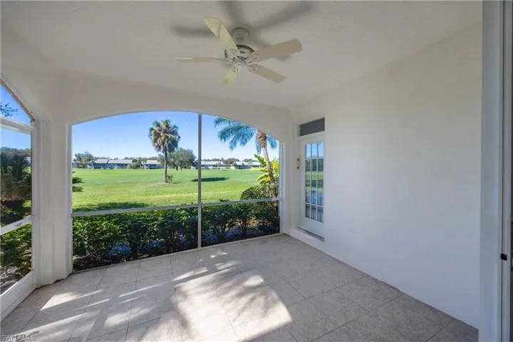 Unfurnished sunroom with ceiling fan and view of golf course