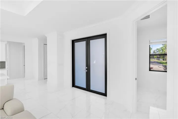 Unfurnished room featuring ornamental molding and light marble finish floors