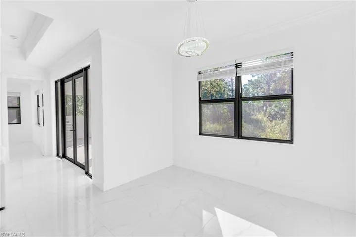 Empty room featuring crown molding and light marble finish floors