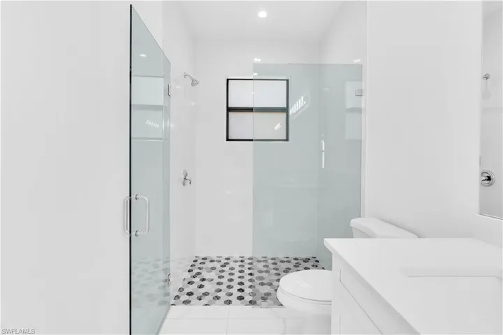 Full bath with vanity, a stall shower, and light tile patterned flooring