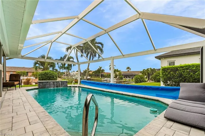 Outdoor pool featuring glass enclosure, a patio area, and a sunroom