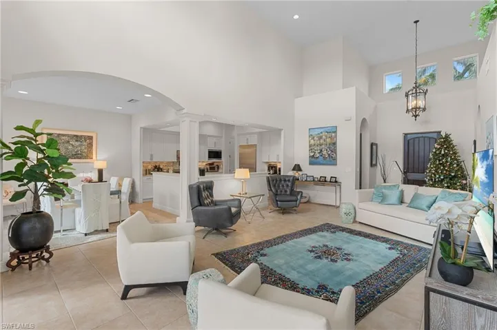 Tiled living room with a towering ceiling and an inviting chandelier