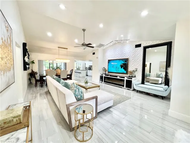 Expansive living area featuring vaulted ceilings, recessed lighting, and large format plank-style tile flooring