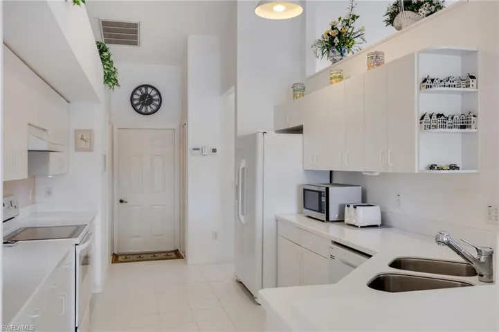 Kitchen with open shelves, white appliances, premium range hood, a high ceiling, and white cabinets