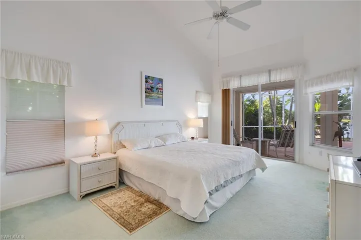 Bedroom featuring access to exterior, high vaulted ceiling, carpet floors, and ceiling fan