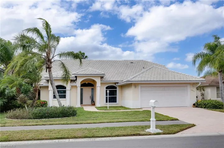 Mediterranean / spanish-style house with a front yard, concrete driveway, stucco siding, and a garage