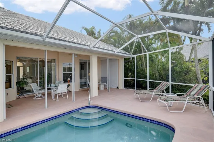 Swimming pool with a sunroom, glass enclosure, and a patio