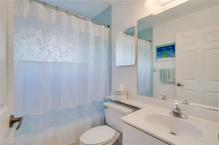Bathroom with curtained shower and vanity
